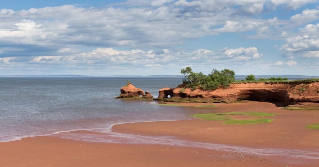 Dramatic coastline along the Bay of Fundy showcasing impressive tides against rocky cliffs.