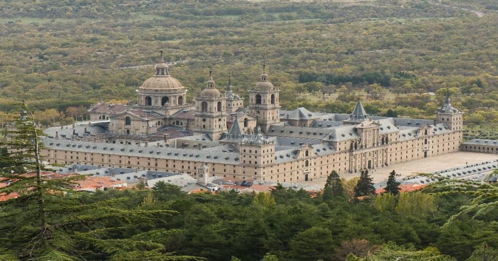  The grand façade of El Escorial with its towering spires and neatly manicured gardens.