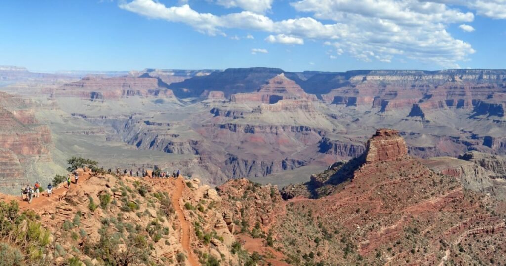 A breathtaking view of the Grand Canyon at sunset with vibrant colors illuminating the rock formations.