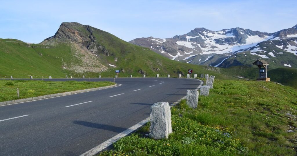  The winding Grossglockner High Alpine Road is surrounded by snow-capped peaks and alpine meadows in Austria.