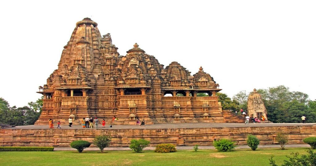 Khajuraho Temples, featuring ornate stone carvings and towering spires amidst a lush green landscape.