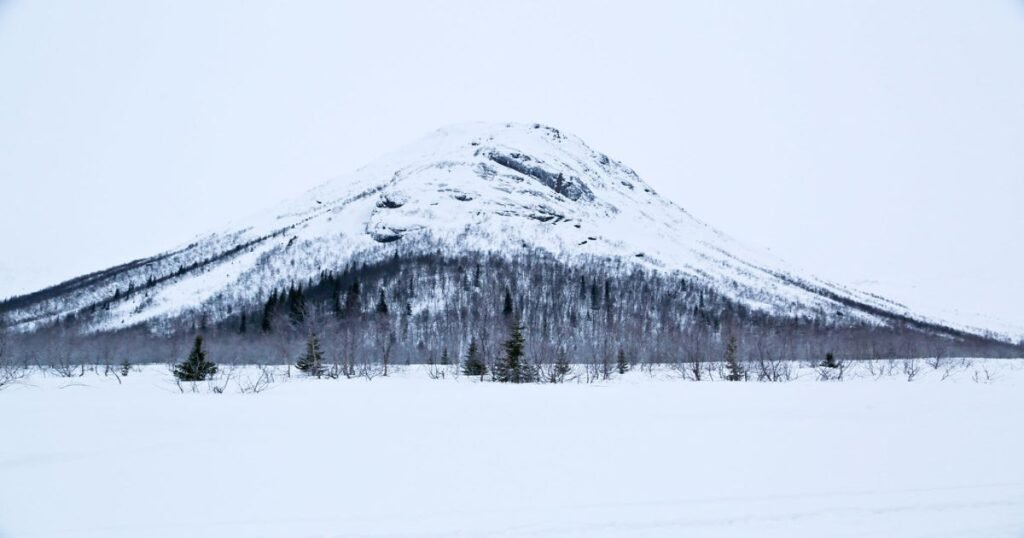 “Snow-covered slopes of the Khibiny Mountains, perfect for skiing, with a backdrop of the Arctic tundra.”