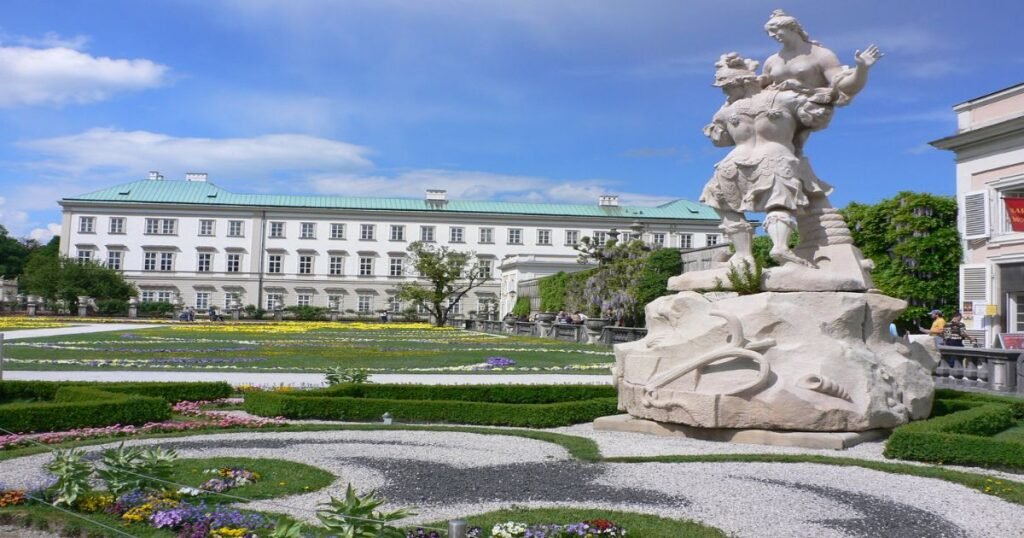  The beautifully manicured gardens of Mirabell Palace with vibrant flowers and fountains in the foreground.