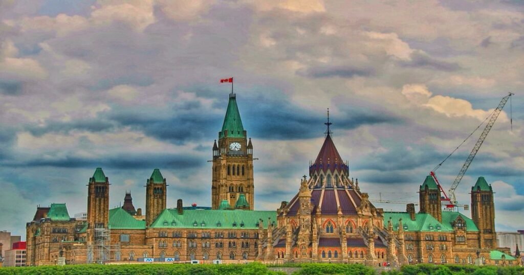 The iconic Parliament Hill buildings with their Gothic architecture against a blue sky in Ottawa.