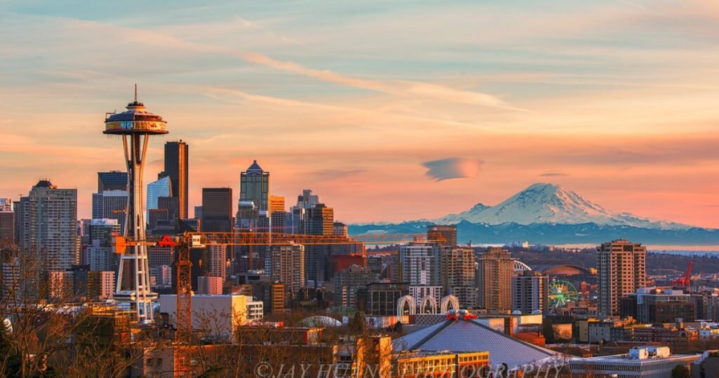 Seattle skyline featuring Space Needle against Mount Rainier backdrop.