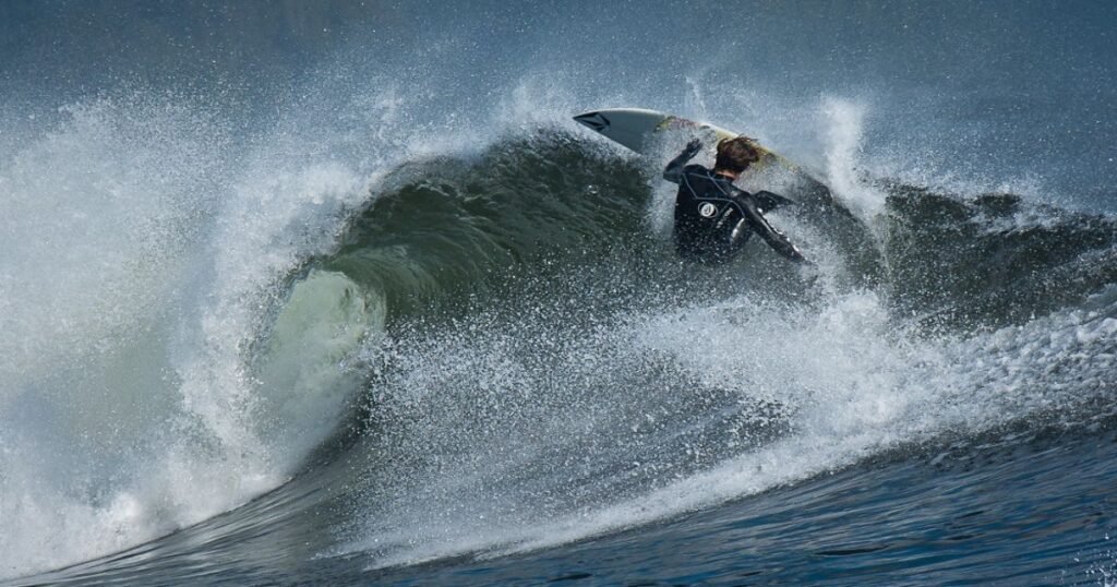 “Surfers riding the waves at Long Beach in Tofino, with the Pacific Ocean stretching out to the horizon.”