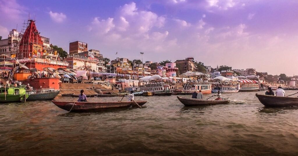 Varanasi’s ghats with people performing rituals and the Ganges River in the background.