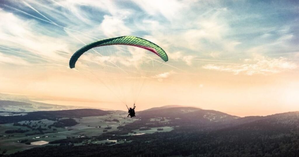 Paragliders soaring over the Dhauladhar range in Bir-Billing, celebrated as India's paragliding capital.