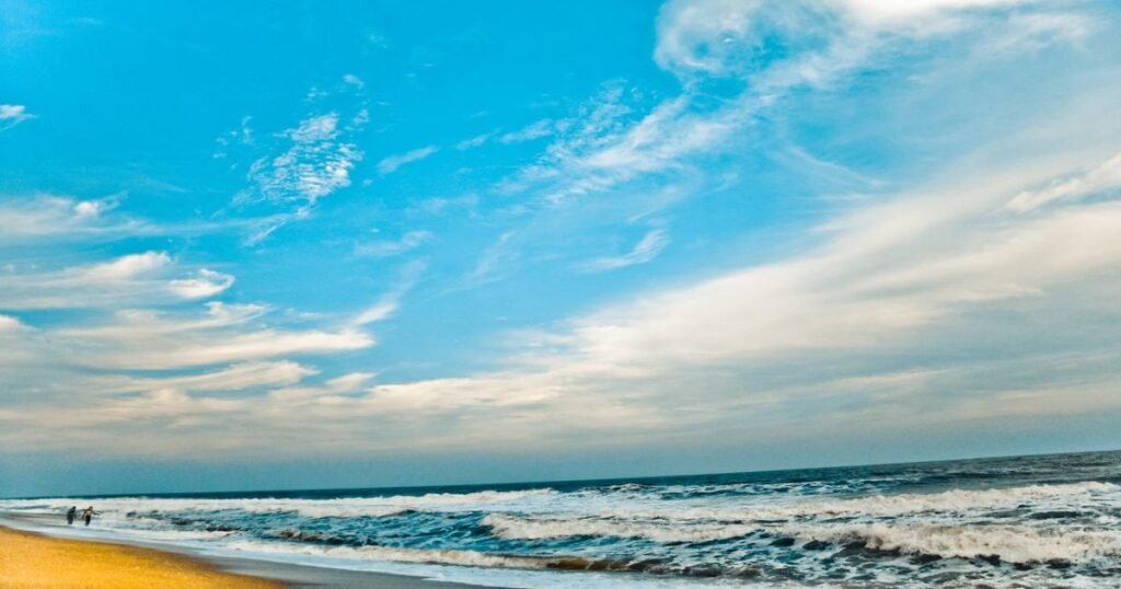 Surfers riding waves in the clear waters of Pondicherry, a unique coastal destination for adventure sports.