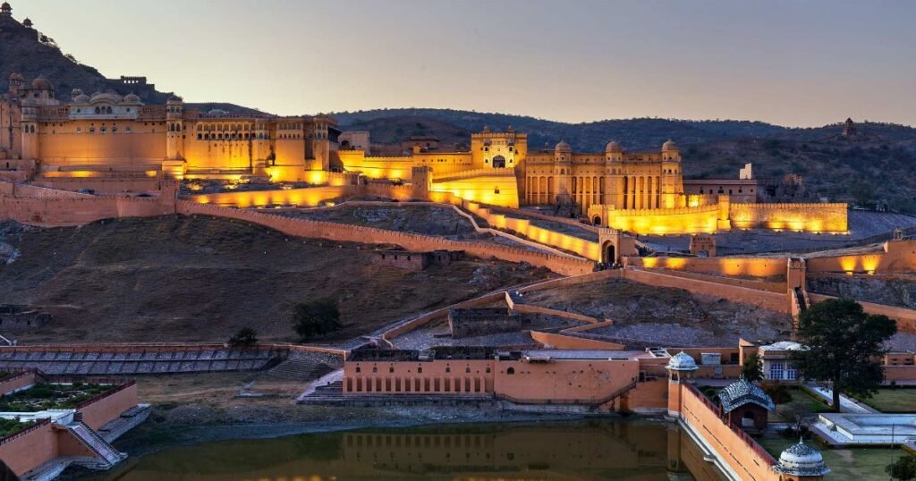 “Amer Fort’s majestic architecture with a backdrop of rugged hills and a serene lake view.”