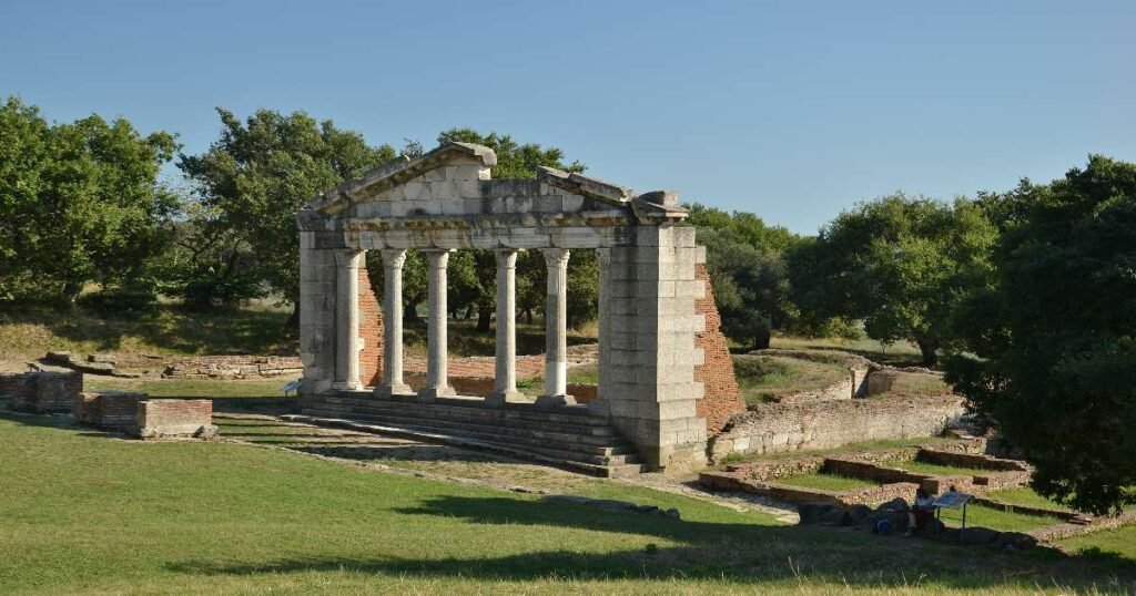  "Ruins of the ancient Greek city of Apollonia surrounded by olive trees."