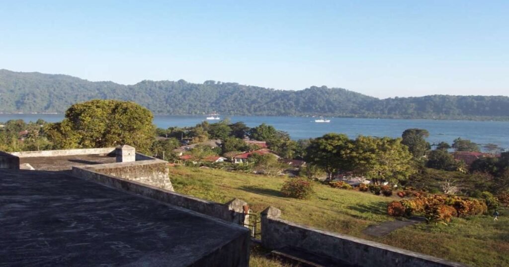 "Banda Islands’ scenic coastline with clear blue water and volcanic backdrop."