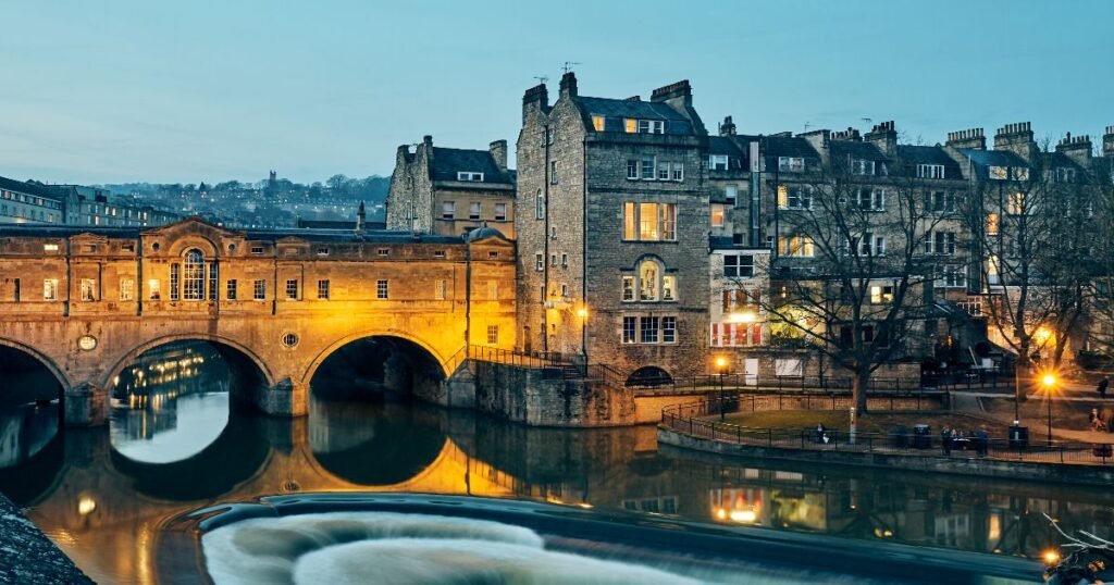 “The Roman Baths in Bath, with steam rising from the thermal waters and Bath Abbey visible in the background.”