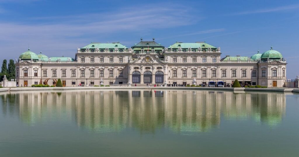“The elegant Belvedere Palace surrounded by beautifully landscaped gardens.”