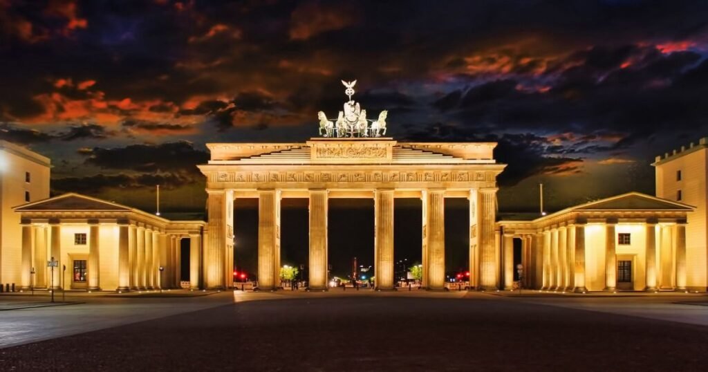 The illuminated Brandenburg Gate at night in Berlin, a symbol of German unity and peace.