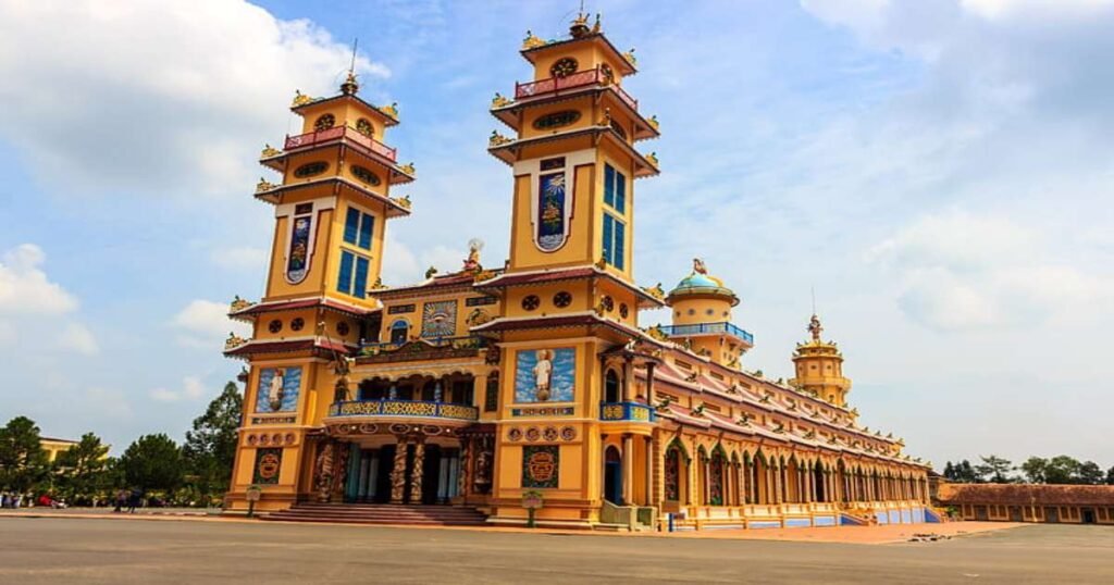 "The vibrant and colorful exterior of the Cao Dai Temple in Tay Ninh, Vietnam, with ornate carvings and religious symbols."