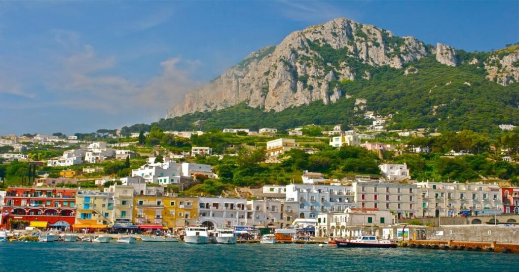 “Capri Island’s rugged coastline and crystal-clear blue waters, viewed from the cliffs of Monte Solaro.”