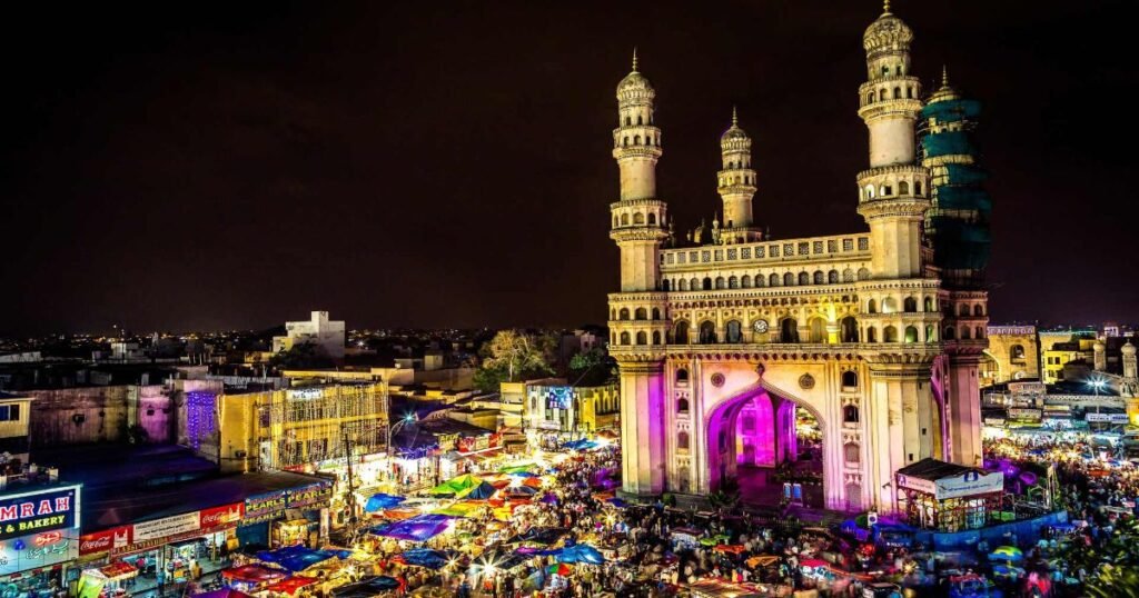 “Charminar’s four minarets towering over the bustling markets of Hyderabad.”
