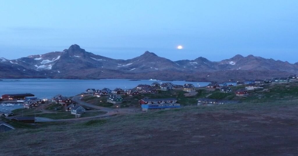 East Greenland, with colorful houses and mountains in the back.