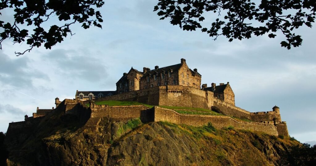 “Edinburgh Castle sitting atop Castle Rock, with the cityscape of Edinburgh in the background.”