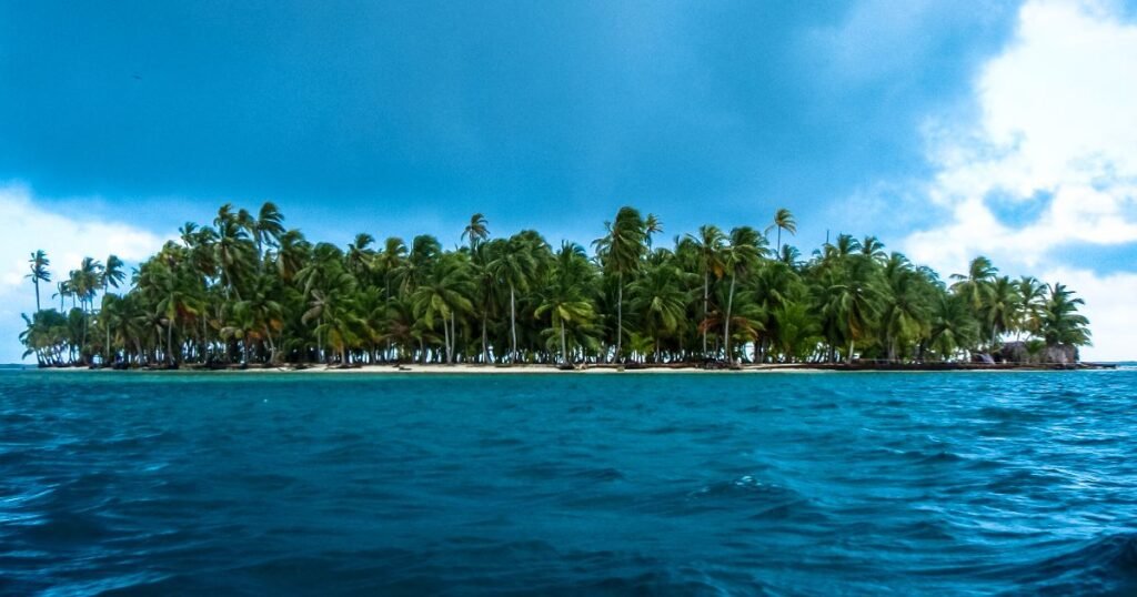 White sandy beach and turquoise waters of the San Blas Islands, with palm trees swaying gently in the breeze.”