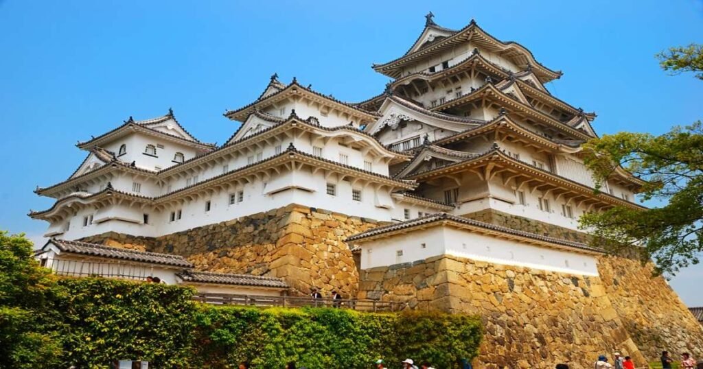 "The white walls and striking towers of Himeji Castle standing against a blue sky."