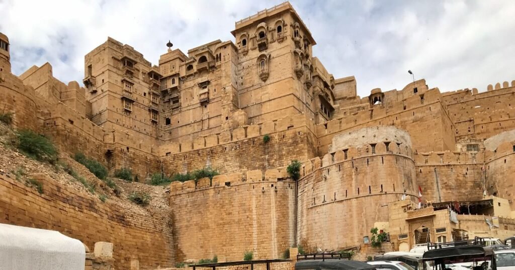 “Jaisalmer Fort’s golden sandstone walls glowing under the bright desert sun.”