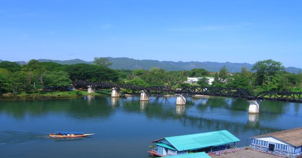 “Historic Bridge over the River Kwai in Kanchanaburi, Thailand, surrounded by lush green hills.”