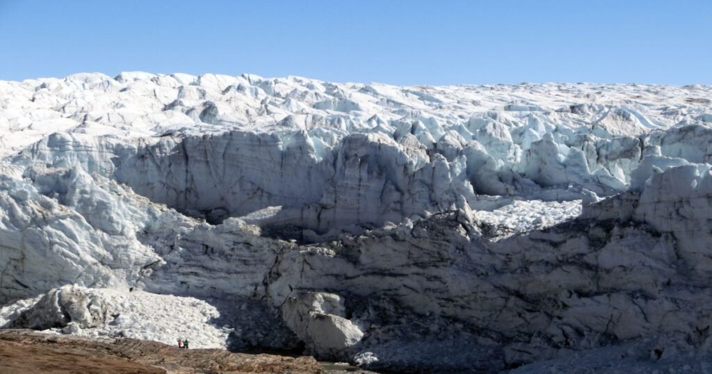 “The dramatic ice cliffs of Russell Glacier, surrounded by snow-covered terrain and the vast Greenland Ice Sheet.”