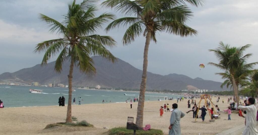 Clear turquoise waters of Khor Fakkan Beach against the backdrop of Hajar Mountains.