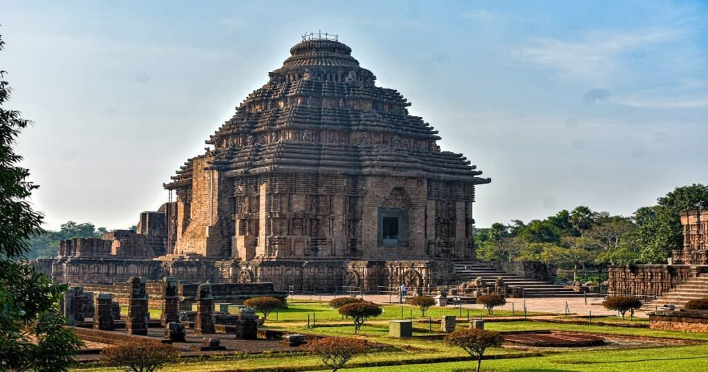 “Konark Sun Temple’s majestic chariot-shaped structure with detailed stone carvings under a clear sky.”