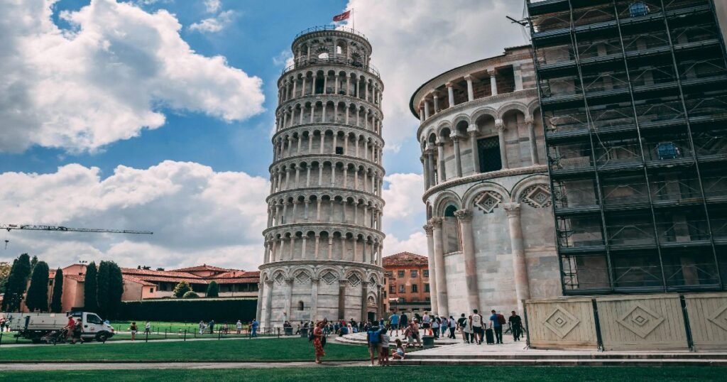 “Leaning Tower of Pisa, a white marble tower with a distinct tilt against a clear blue sky.”