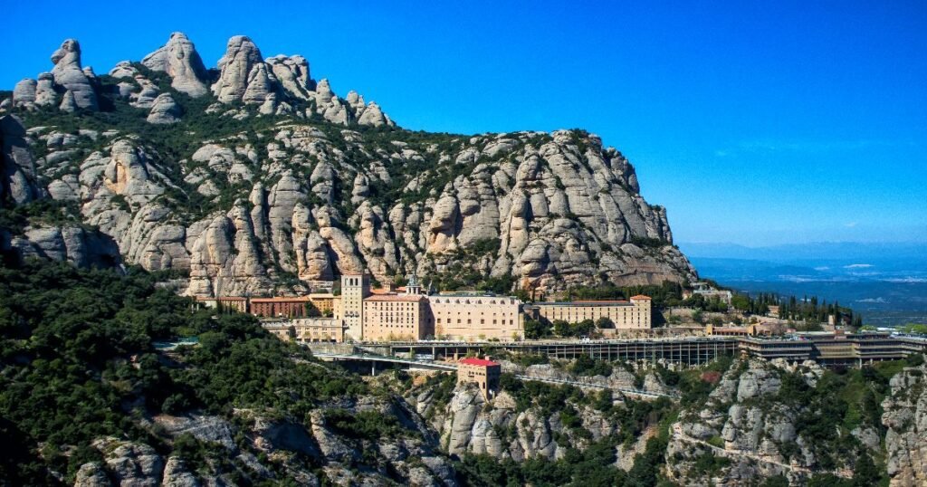  Hikers ascending the trails of Montserrat with its distinctive rock formations in the background.