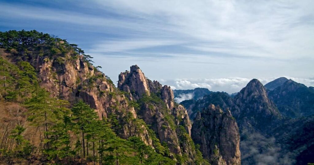 "Granite peaks and ancient pine trees shrouded in mist at Mount Huangshan."