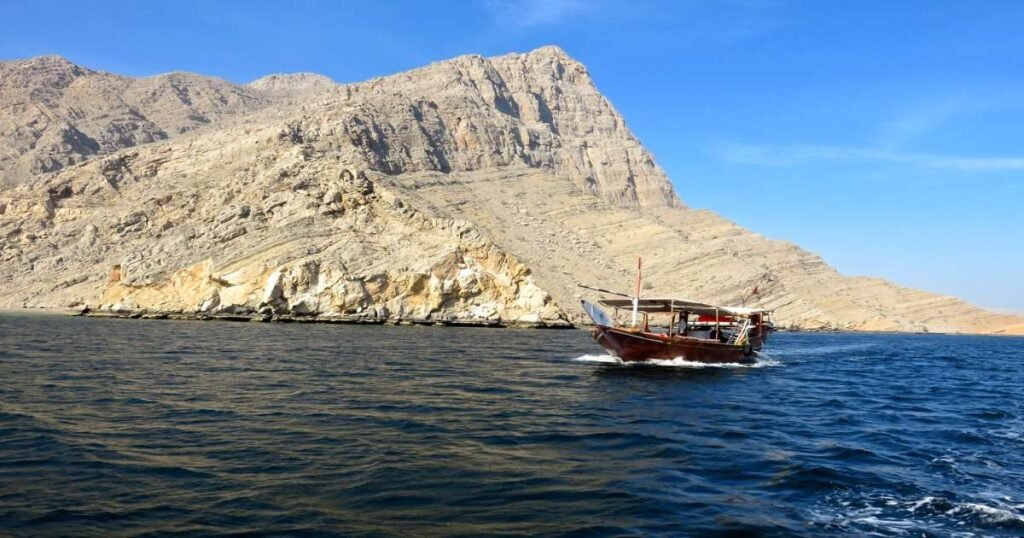 Traditional dhow boat cruising through the fjords of Musandam Peninsula.