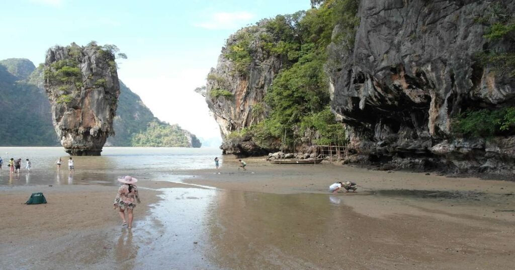 “Emerald-green waters of Phang Nga Bay with limestone karsts rising majestically against the blue sky.”