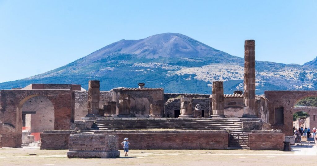 “Ruins of Pompeii with Mount Vesuvius in the background, showcasing ancient Roman architecture.”