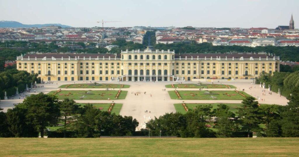 “The grand façade of Schönbrunn Palace with vibrant gardens and a bright blue sky.”