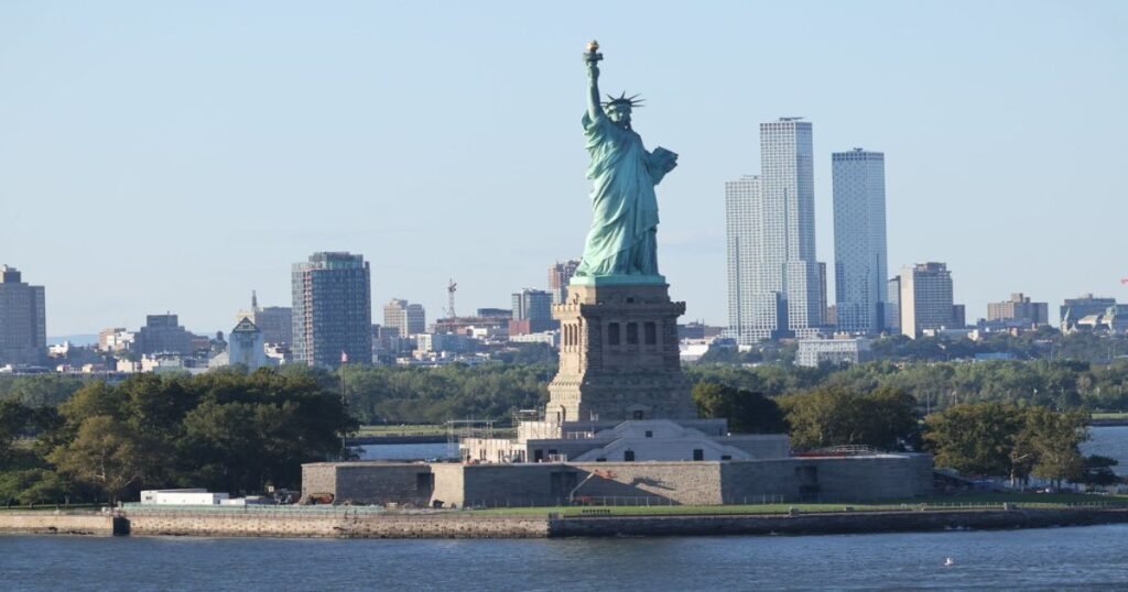 “Statue of Liberty’s majestic figure overlooking the New York skyline, symbolizing freedom and hope.”