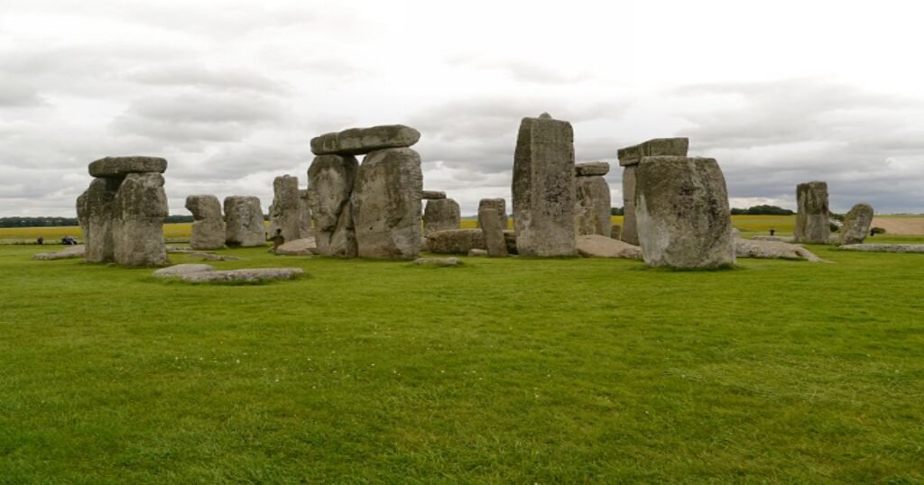 “Stonehenge, a prehistoric stone circle on Salisbury Plain, silhouetted against a setting sun.”