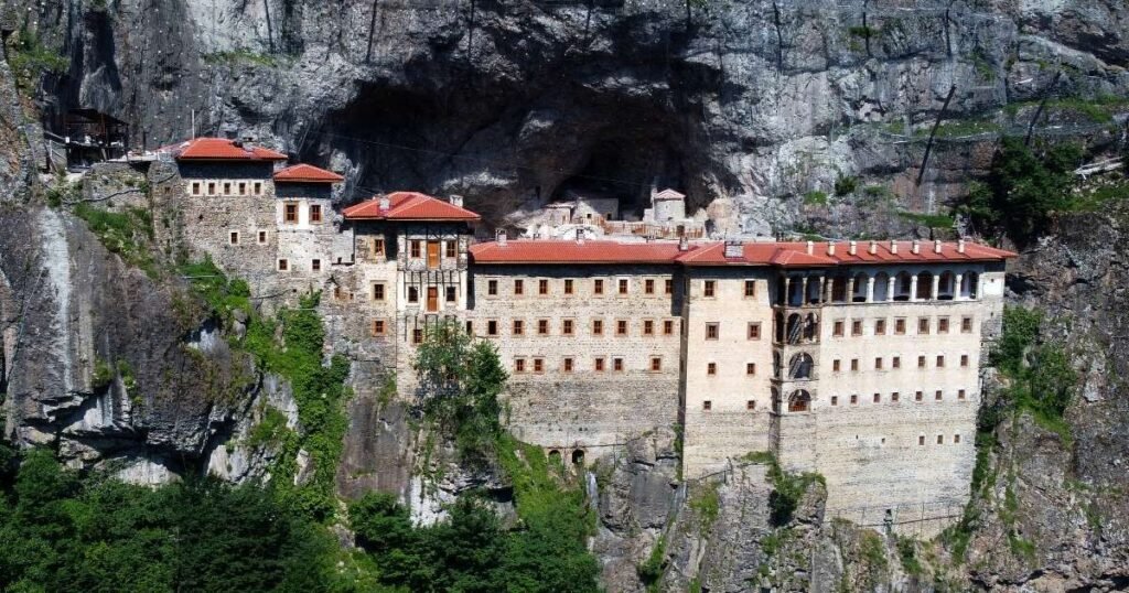 "The stunning Sumela Monastery, nestled into a cliffside in the lush Pontic Mountains, with its intricate frescoes and breathtaking views."