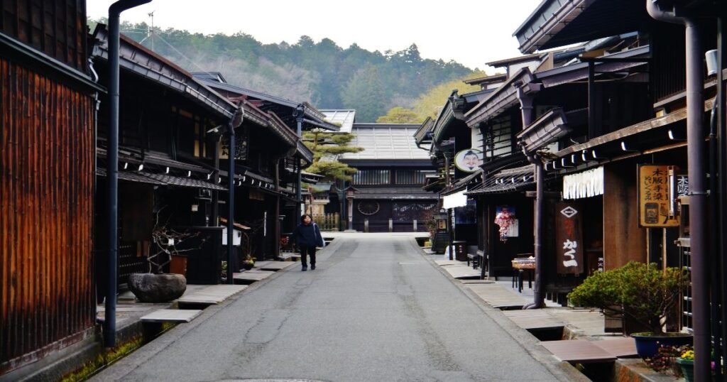 "Traditional wooden houses lining the narrow streets of Takayama’s Old Town, with lanterns hanging outside the shops."