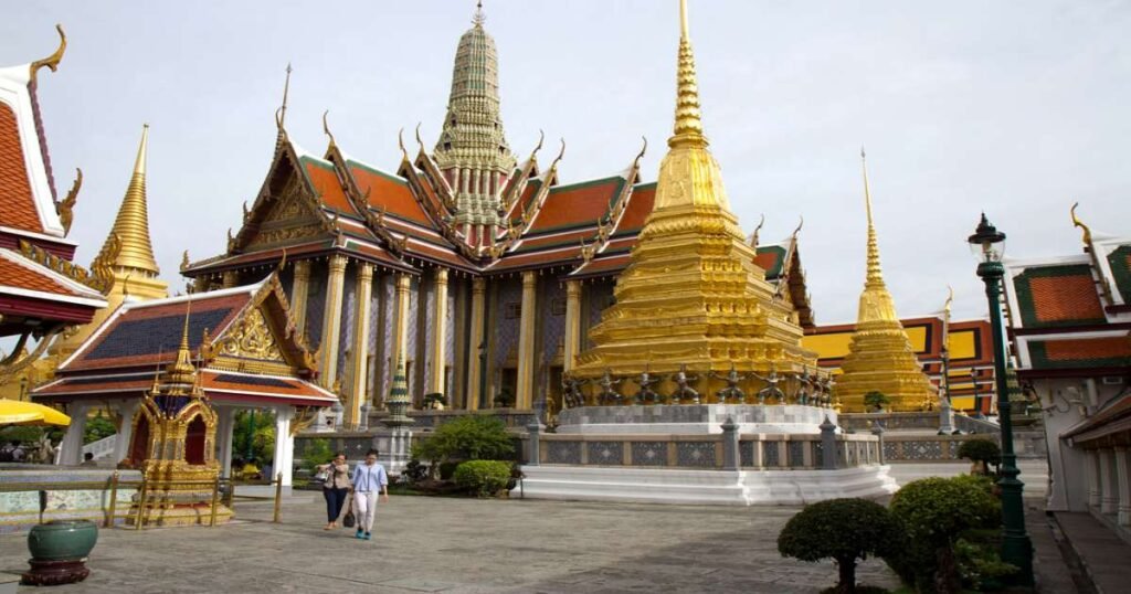 “The Grand Palace in Bangkok, with its golden spires and colorful, intricate architecture.”