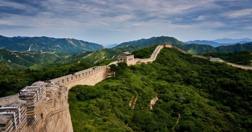 "Panoramic view of the Great Wall of China snaking through rugged mountains."