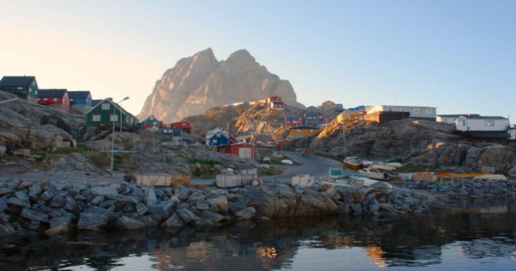 Uummannaq town, with colorful houses clustered at the base of the towering Heart-Shaped Mountain, overlooking the icy waters of the fjord.