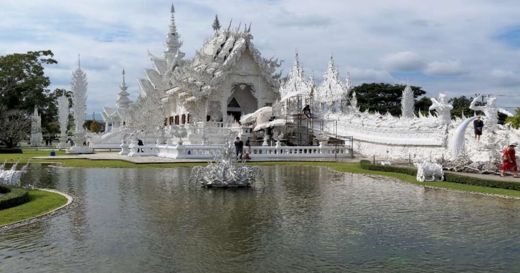 “The stunning white facade and intricate mirror details of Wat Rong Khun in Chiang Rai.”