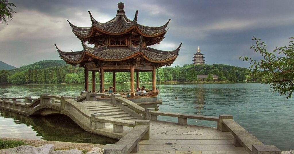 "A serene view of West Lake, with pagodas and lotus flowers dotting the landscape."