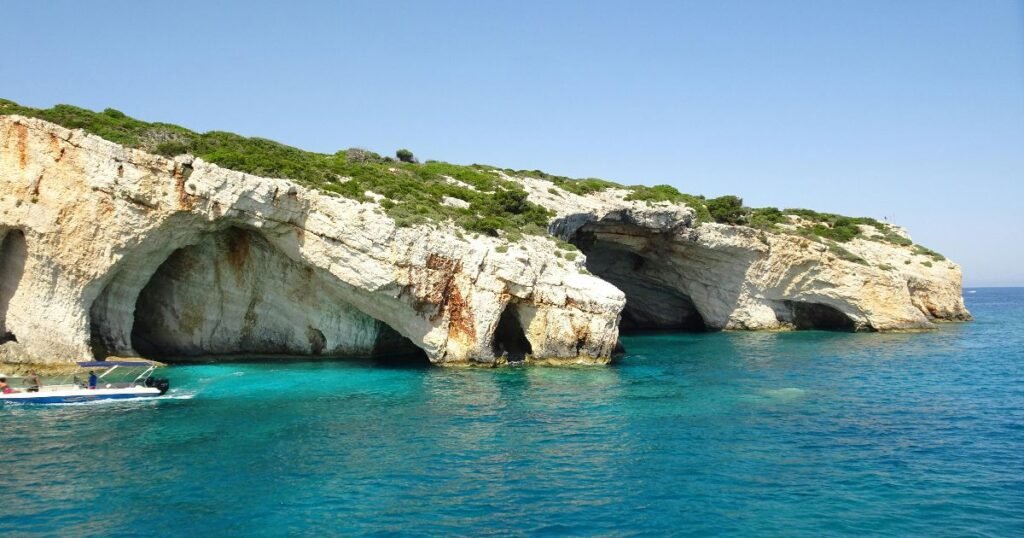 "Navagio Beach with crystal-clear waters and a shipwreck on the sandy shore of Zakynthos, Greece."