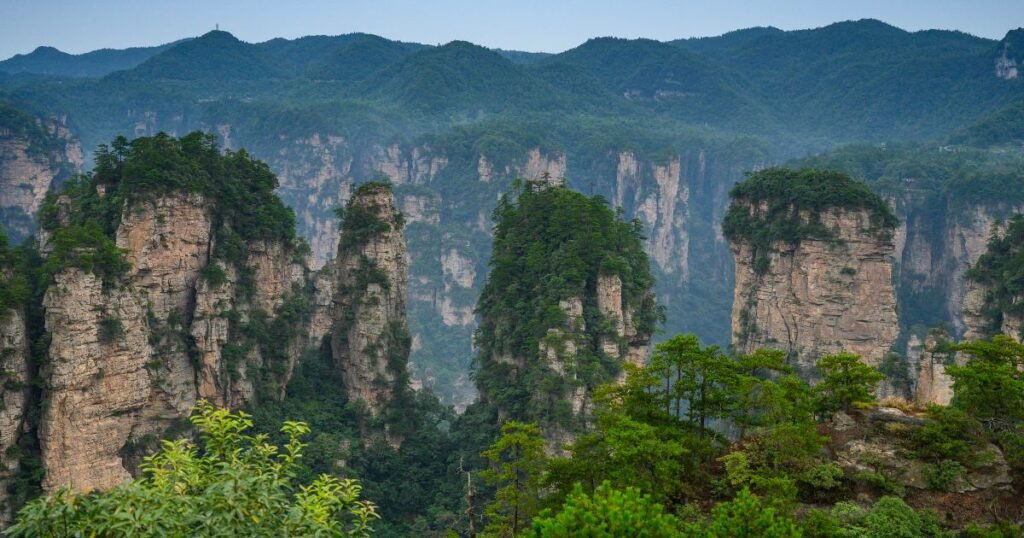 "Majestic sandstone pillars covered in greenery at Zhangjiajie National Forest Park."