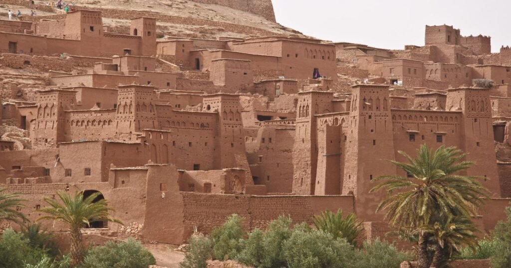 "Aït Benhaddou with its clay buildings and mountains in the background."